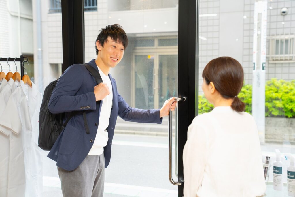 イメージ：院長が店舗から出ようとしている様子。プロフェッサーズラウンドスタッフが挨拶している様子